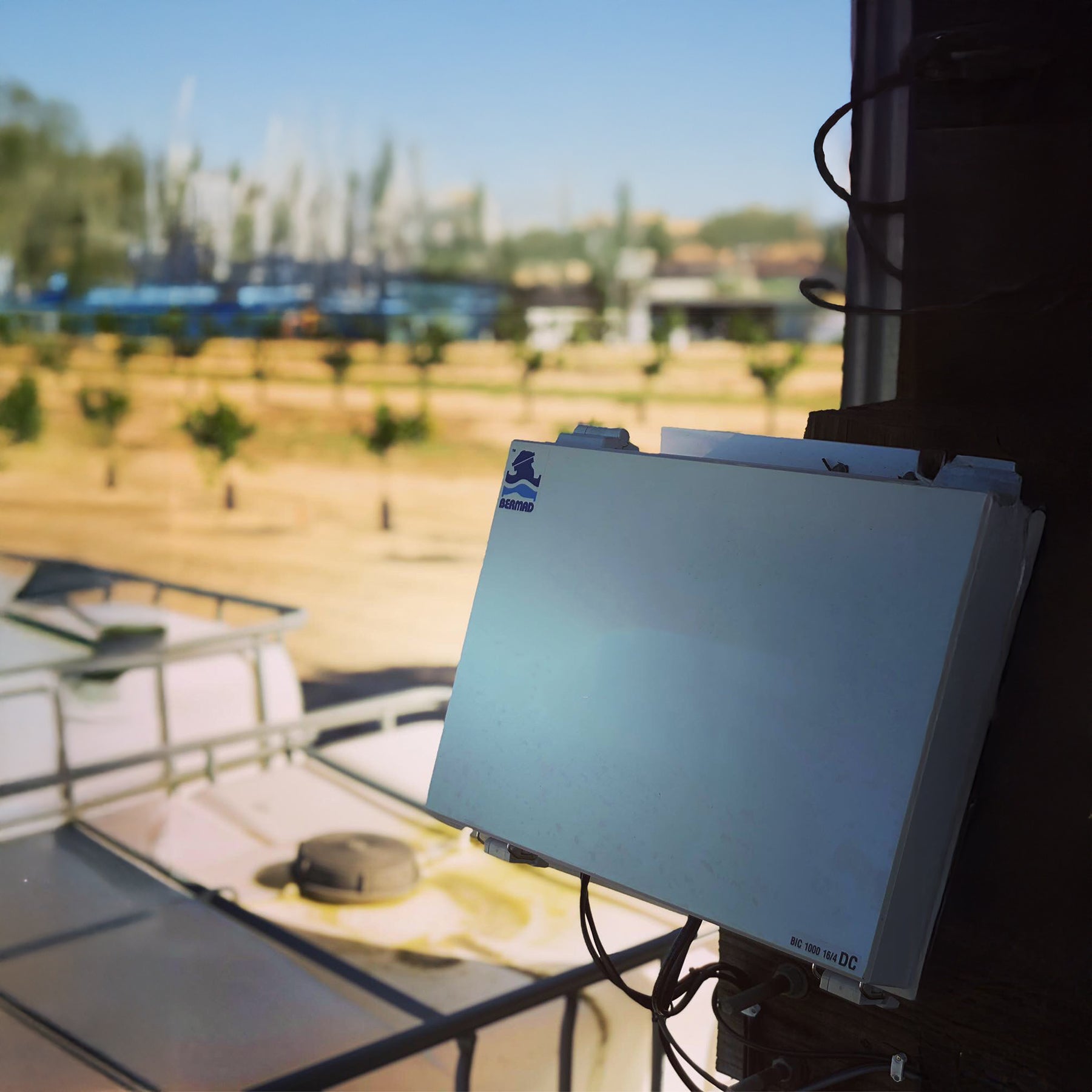 Electronic device on a boat with a blurred background of water and trees
